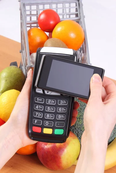 Lector de tarjetas de crédito y teléfono móvil con tecnología NFC, frutas y verduras, pago sin efectivo para compras — Foto de Stock
