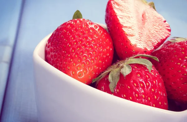 Photo vintage, Fraises fraîches mûres dans un bol en verre sur des planches, dessert sain — Photo