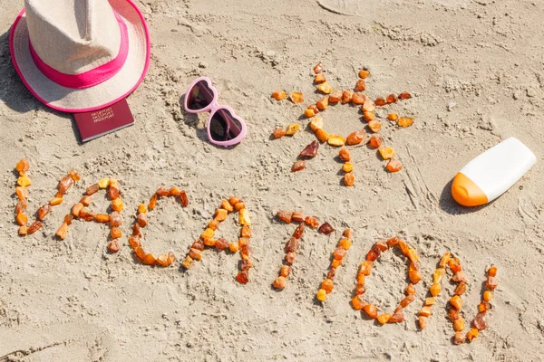 Słowa wakacje, akcesoria do opalania i paszport na piasku plaży, koncepcja czasu letniego — Zdjęcie stockowe