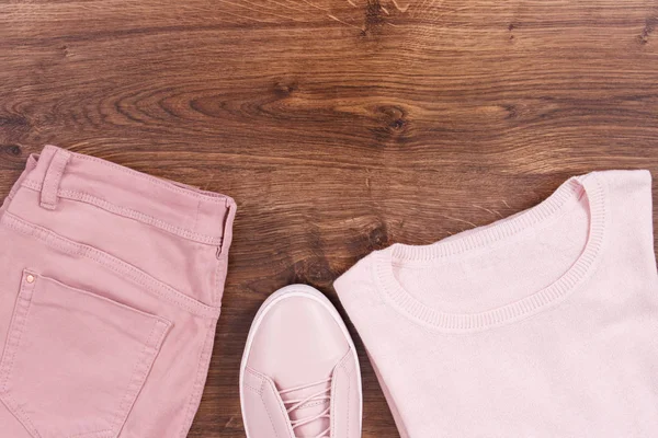 Жіноче рожеве шкіряне взуття, штани та светр на сільських дошках, копіювання простору для тексту — стокове фото