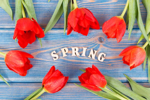 Red tulips and inscription spring on boards, springtime decoration — Stock Photo, Image