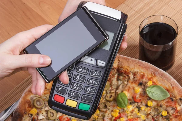 Using payment terminal and mobile phone with NFC technology for paying in restaurant