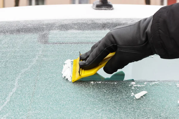 手在手套刮冰从汽车挡风玻璃 — 图库照片