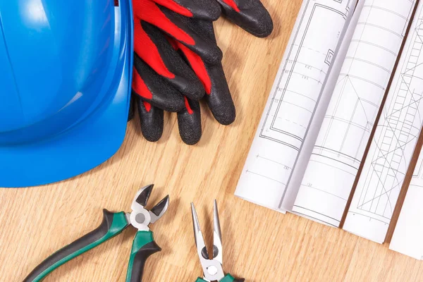 Rolls of electrical drawings, protective helmet with gloves and work tools