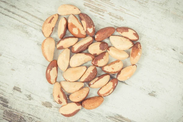 Vintage photo, Heap of brazil nuts in shape of heart, healthy food containing natural minerals