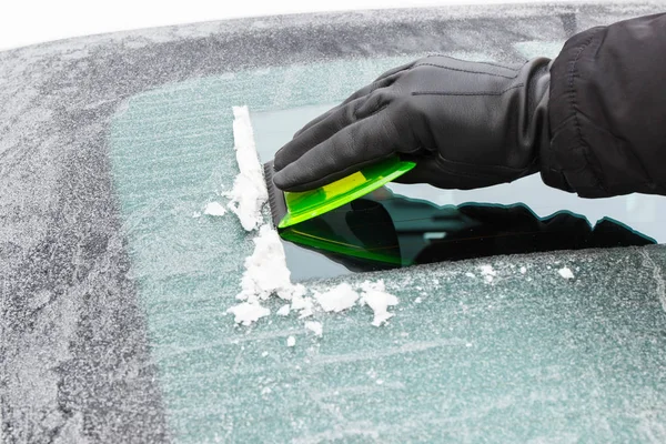 Mão na luva raspando gelo do pára-brisas do carro — Fotografia de Stock