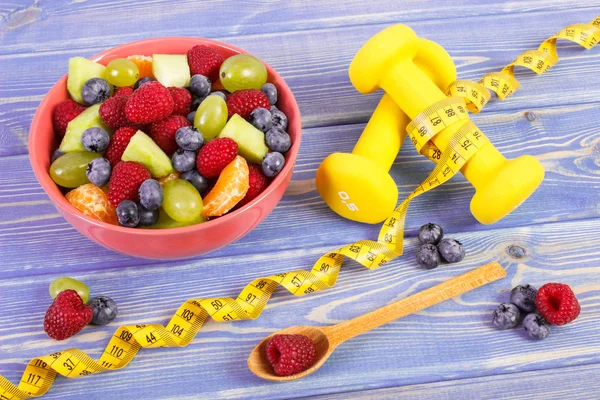 Insalata di frutta e centimetro con manubri, stile di vita sano e concetto di nutrizione — Foto Stock