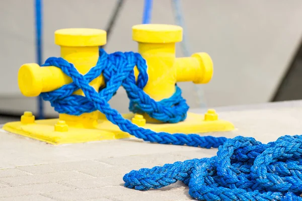 Blue rope and mooring bollard in port, parts of seaport and yacht — Stock Photo, Image