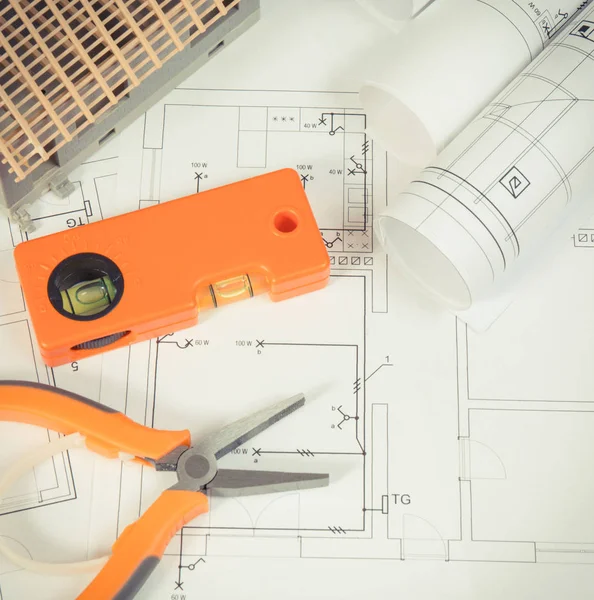Electrical diagrams, orange work tools for engineer jobs and house under construction, building home concept