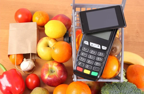 Terminal de pago y teléfono móvil con tecnología NFC, frutas y verduras, pago sin efectivo para compras — Foto de Stock