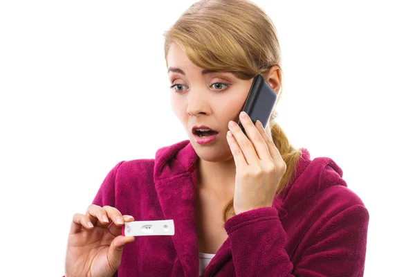 Orolig kvinna med telefon informera någon om positiva graviditetstest — Stockfoto