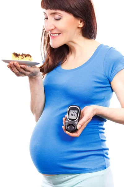 Femme enceinte tenant glucomètre avec le taux de sucre résultat et morceau de gâteau au fromage, diabète pendant la grossesse — Photo