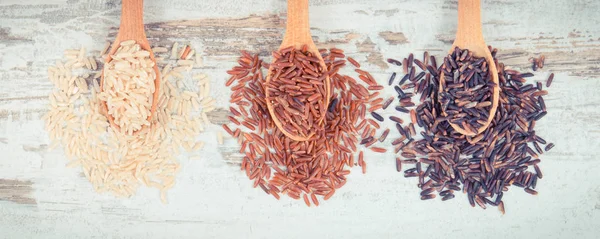 Foto d'epoca, riso marrone, nero e rosso su cucchiai di legno, sano concetto di cibo senza glutine — Foto Stock