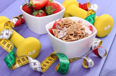 Taze çilek, buğday ve çavdar pul, halter ve santimetre, sağlıklı ve sportif yaşam kavramı