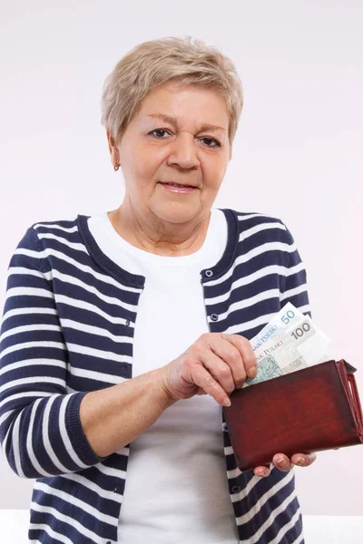 Счастливая пожилая женщина с кошельком с польскими валютными деньгами, концепция финансов в старости — стоковое фото