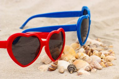Yığın kabukları ve kum plaj, yaz ve tatil zaman kavramı üzerinde güneş gözlüğü