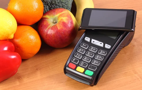 Terminal de pago y teléfono móvil con tecnología NFC, frutas y verduras, pagando por las compras — Foto de Stock