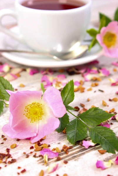 野生玫瑰花和杯茶在老土气板上 — 图库照片