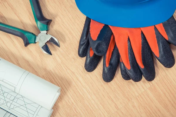 Rolos de desenhos elétricos, capacete de proteção com luvas e ferramentas de trabalho, acessórios para trabalhos de engenharia — Fotografia de Stock