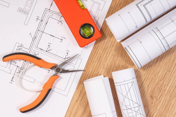 Planos ou diagramas eléctricos e ferramentas de trabalho cor-de-laranja para utilização em trabalhos de engenharia — Fotografia de Stock