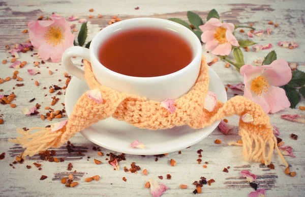 Vintage foto, xícara de chá quente com flor de rosa selvagem no velho fundo de madeira rústica — Fotografia de Stock
