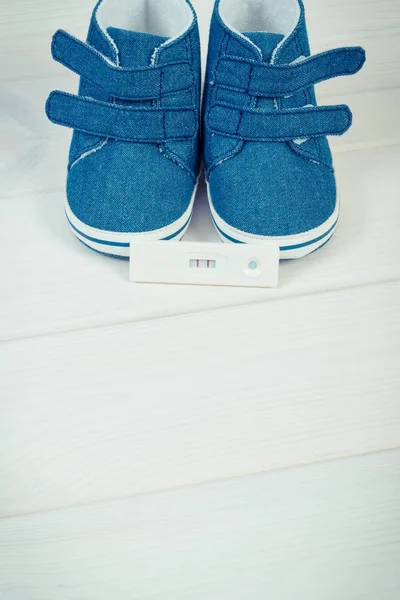 Foto vintage, teste de gravidez com resultado positivo e sapatos de bebê para recém-nascido, esperando pelo conceito de bebê — Fotografia de Stock
