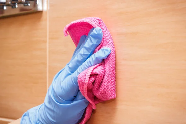 Hand of senior woman wiping bathroom tiles using pink microfiber cloth, household duties concept — Stock Photo, Image