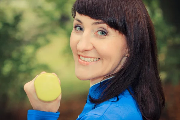 Mujer sonriente haciendo ejercicio con pesas en el parque, estilo de vida saludable al aire libre —  Fotos de Stock