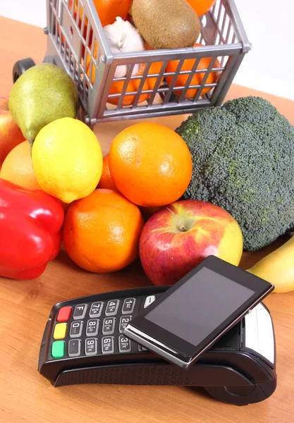 Terminal de pago y teléfono móvil con tecnología NFC, frutas y verduras. Pagar sin efectivo por concepto de compras — Foto de Stock