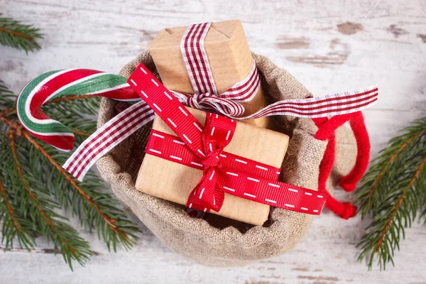 Δώρα για τα Χριστούγεννα ή του Αγίου Βαλεντίνου στη Γιούτα σάκο και έλατο κλαδιά — Φωτογραφία Αρχείου