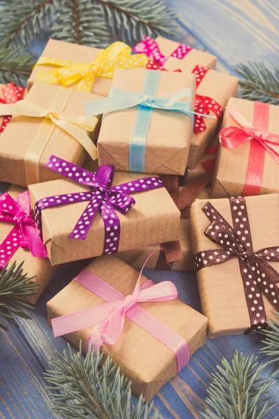 Regalos envueltos con cintas de colores para Navidad y ramas de abeto — Foto de Stock