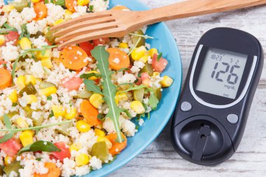 Şeker seviyesini ölçmek için glukometre ve kuskus ve sebzeli salata diyabet, diyet ve zayıflatma için en iyi besleyici gıda olarak
