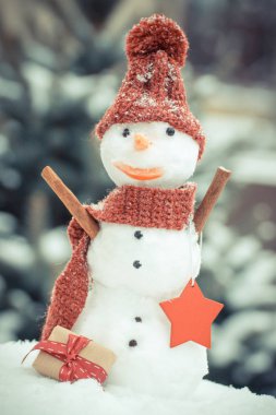 Vintage Fotoğraf, kardan adam ile iğne yapraklı ağaç arka plan üzerinde Noel ya da Sevgililer günü için hediye kar kaplı.