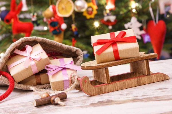Julklappar på släde och i säck, julgran med dekoration, festligt koncept — Stockfoto