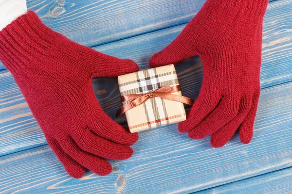 Mains de femme en gants avec cadeau pour Noël ou autre célébration — Photo