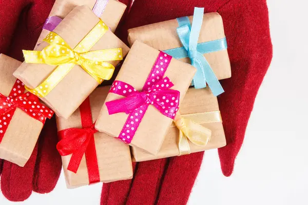 Mains de femme en gants avec des cadeaux pour Noël ou toute autre célébration — Photo