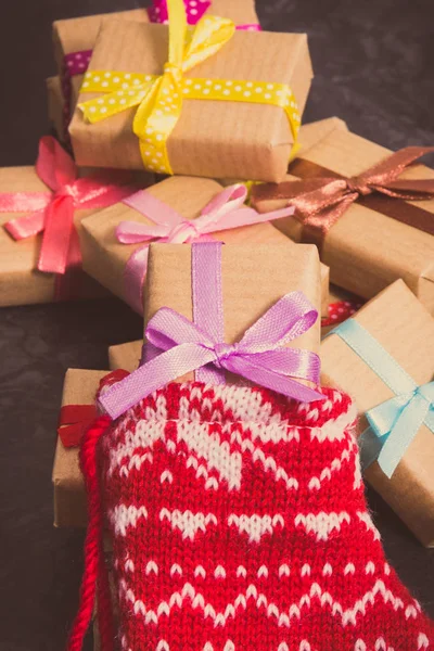 Τυλιγμένα δώρα για τα Χριστούγεννα και εορταστική κόκκινη κάλτσα — Φωτογραφία Αρχείου
