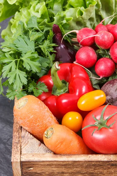 Fresh ripe vegetables in wooden box as healthy snack containing vitamins — Stock Photo, Image