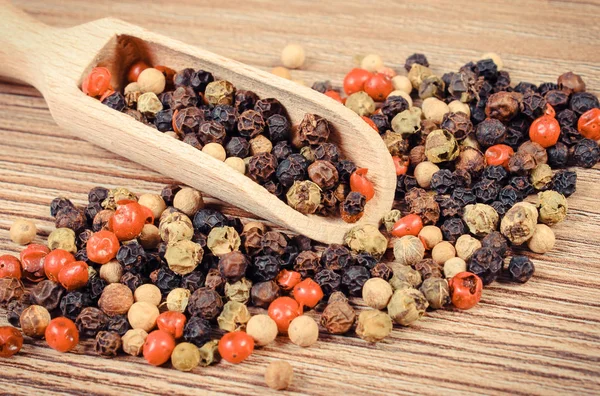 Pimenta colorida com colher de madeira ou colher a bordo. Especiarias para cozinhar — Fotografia de Stock