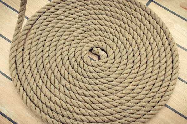 Thick rope wrapped in spiral on deck of ship — Stock Photo, Image