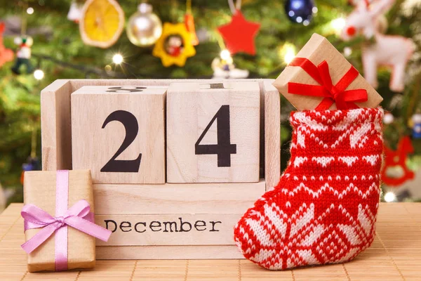 Datum 24 December på kalender, gåvor med röd strumpa och festligt träd med dekoration, julafton tid koncept — Stockfoto