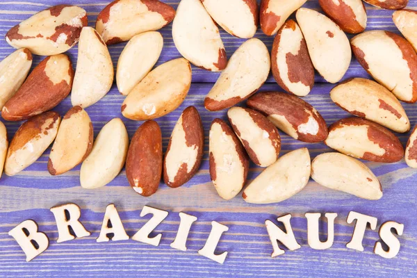 Надпись бразильские орехи и куча фруктов как источник природных минералов и витамина — стоковое фото