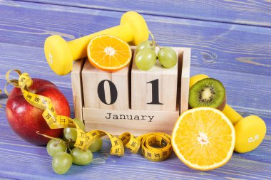Takvim, meyve, halter ve şerit metre, yeni yıl kararları kavramı küp