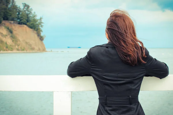 Woman sitting on beach and looks at sea. Summer time concept — Stock Photo, Image