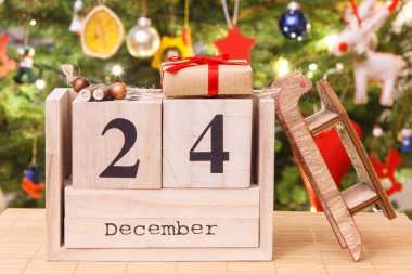 24 Aralık tarihli küp takvimi, paketlenmiş hediyeler ve süslemeli Noel ağacı, Noel arifesi konsepti