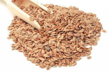 Beyaz arka plan üzerinde tahta kaşık ile Keten tohumu. Diyet lifi içeren sağlıklı gıdalar