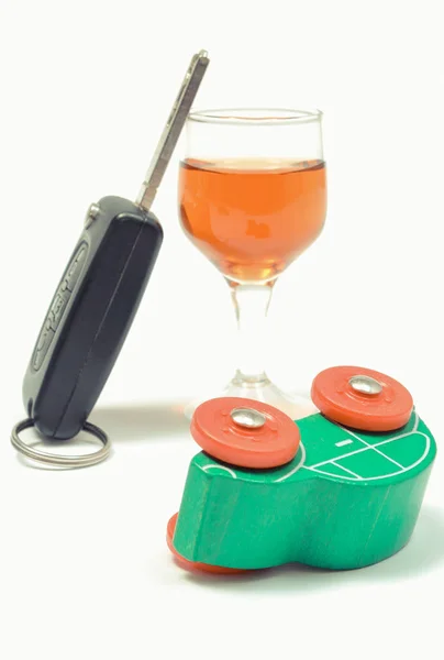 Overturned toy car, glass of wine and car key. Don't drink and drive. White background — Stock Photo, Image