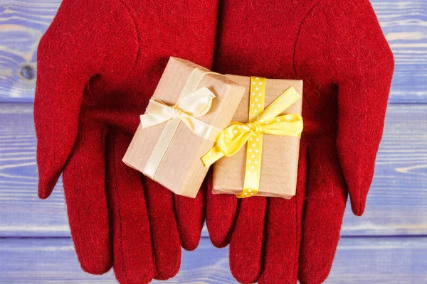 Τα χέρια της γυναίκας στα γάντια με δώρα για τα Χριστούγεννα ή άλλη γιορτή — Φωτογραφία Αρχείου