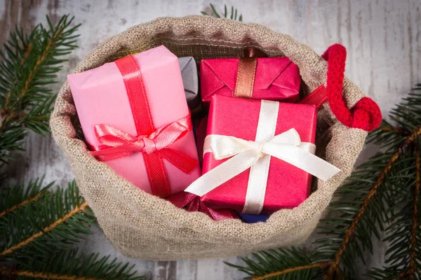 Zapakowane prezenty w worku jute na Boże Narodzenie lub inne święto — Zdjęcie stockowe