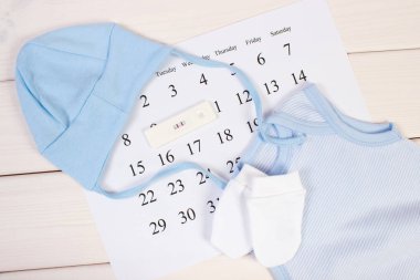 Hamilelik testi pozitif sonuç ve bebek kavramı için bekliyor takvimde yeni doğan için giyim